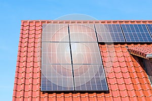 Solar panels or photovoltaic plant on the roof of a house - reflection of the sun