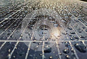 solar panels with rain drops on the surface and sun reflection