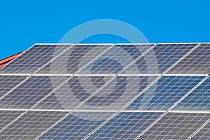 Solar panels on the roof of a building against a blue sunny sky