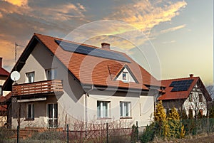 Solar panels red roof of house - sunset photo