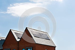 Solar panels on roof of new houses in england uk on bright sunny day