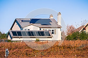 Solar panels on the rooftop of residential buildings; vineyards in the foreground; Livermore, east San Francisco bay, California