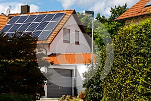 Solar panels on the tiled roof of a building on a bright sunny day. The concept of a good investment, a bargain, an overabundance