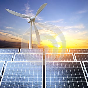 Solar panels and wind turbine against the sunset. Alternative energy concept