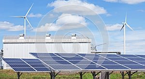 Solar panels and wind turbines generating electricity is solar energy and wind energy in hybrid power plant systems station