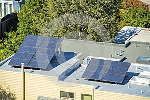 Solar pannels on top of flat roof to help with climate change and front yard trees with stucco beige exterior on house