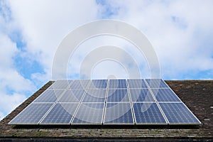 Solar photovoltaic panels on a clay tile roof in England, United Kingdom, with copy space