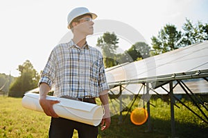 Solar power plant. Man standing near solar panels. Renewable energy