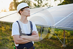 Solar power plant. Man standing near solar panels. Renewable energy