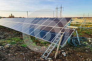 Solar power plant under construction on green field. Assembling of electric panels for producing clean ecologic energy