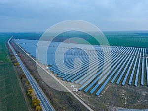 Solar power station in green field near the road. Aerial view. Alternative energy, ecology power conservation concept