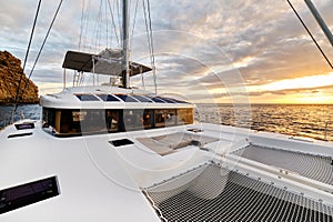 Solar powered catamaran at sunset, fully sustainable and powered by solar energy, charging batteries aboard a sailboat