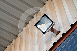 Solar powered led spotlight mounted on the outer wall of the warehouse