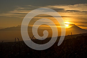 Solar sphere above the volcanoes at dawn