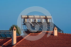 Solar thermal collectors installed on the tiled roof of the house