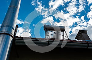 Solar water heater boiler back view between two chimneys