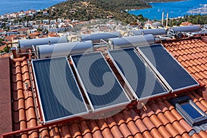 Solar water heater installed on tile roof of house for eco heating of water. Large water tanks. Horizontal photo