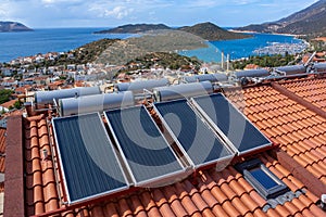 Solar water heater installed on tile roof of house for economical heating of water. A lot of large water tanks. Horizontal photo photo