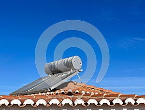 Solar water heater installed on tile roof of house for environmentally