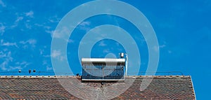 Solar water heater on old rooftop, birds, birds excrements on the water boiler