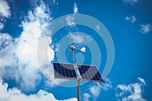 Solar and wind powered lamp. Photovoltaic panel and windmill mounted on the street lamp