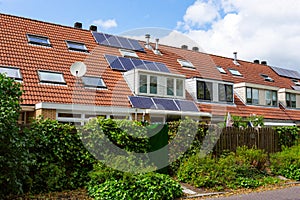 Solarpannels on the orange tiled roof of a terraced house with a dormer in the South-Holland village of Sassenheim