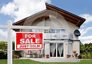 Sold home for sale sign in front of house