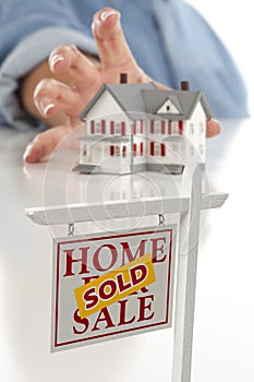 Sold Real Estate Sign in Front, Reaching for House