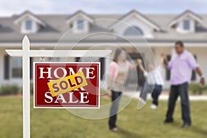 Sold Real Estate Sign and Hispanic Family at House