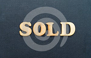 A sold sign on a black background.