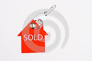 Sold sign and key on a key ring. Real estate sale concept