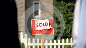 Sold signboard in front of house, real estate agency, property selling business