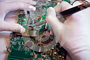 Soldering a circuit board in service laboratory.