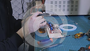 Soldering is done on the microchips in the factory with a soldering machine. electronic working hands.