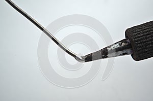 Soldering iron touching wire on a white background