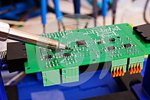 Soldering process on a green PCB closeup