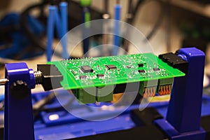 Soldering process on a green PCB closeup