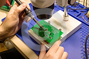 Soldering process on a green PCB closeup
