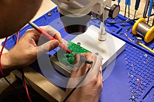 Soldering process on a green PCB closeup