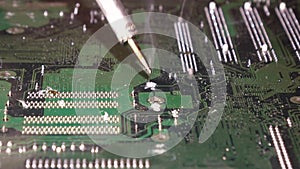 Soldering to a circuit Board of a computer close up.