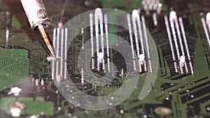 Soldering to a circuit Board of a computer close up.