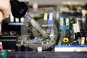 Soldering to a circuit Board of a computer close up.