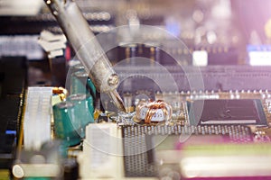 Soldering to a circuit Board of a computer close up.