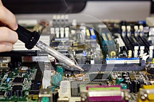 Soldering to a circuit Board of a computer close up.