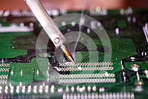 Soldering to a circuit Board of a computer close up.