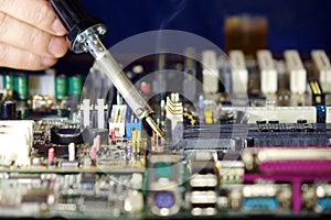 Soldering to a circuit Board of a computer close up.