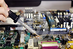 Soldering to a circuit Board of a computer close up.