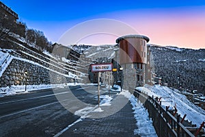 Soldeu sign at entrance to the town, pine forest and mountain range in background, Andorra