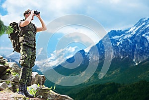 Soldier with backpack looking to binocular