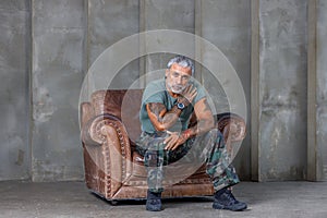 A soldier in camouflage, a soldier stands against the wall.A mature male bodybuilder in a military uniform